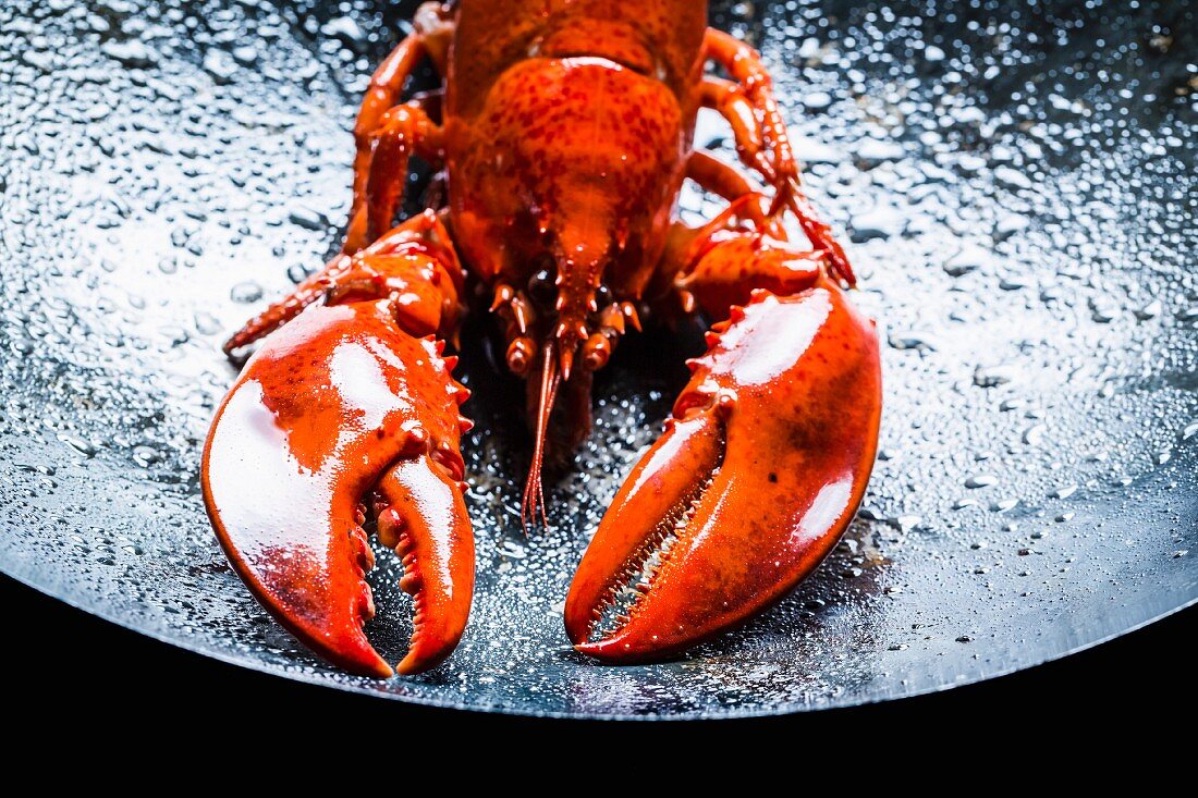 A large lobster in a black wok