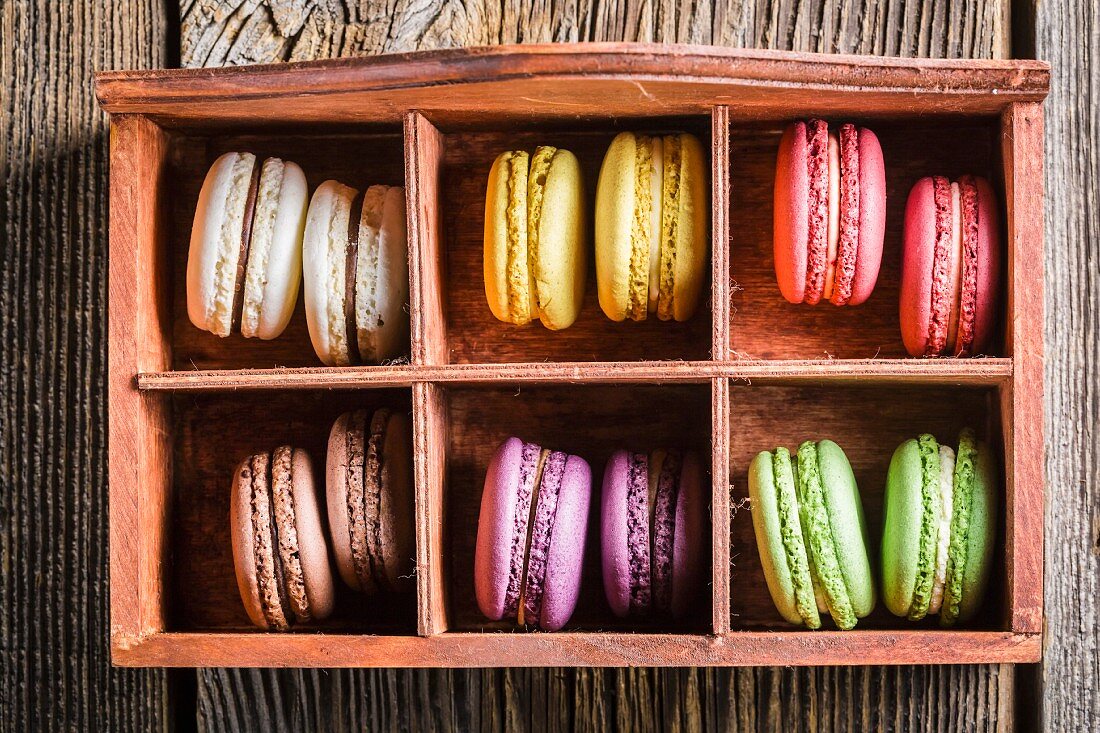 Bunte Macarons in alter Holzkiste