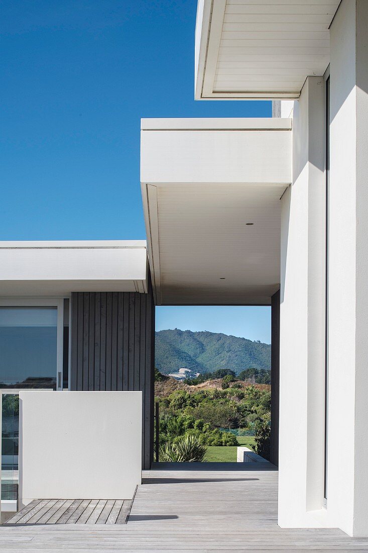 Contemporary house; open doorway leading to garden with view of hills