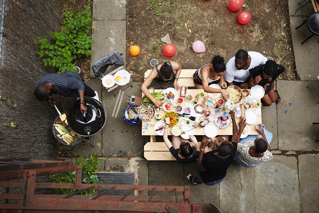 A group of young people having a barbecue in a courtyard (seen from above)