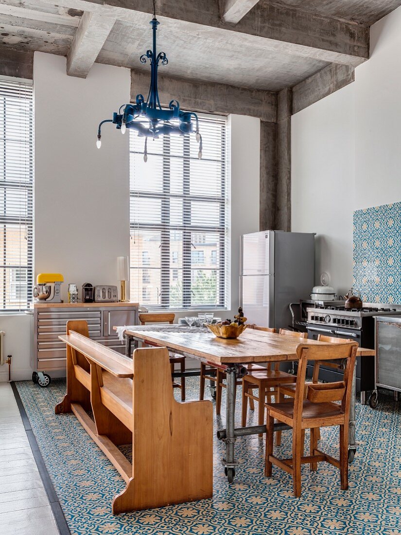 Offene Küche mit Ornamentfliesen und eklektischer Einrichtung vor hohen Industriefenstern