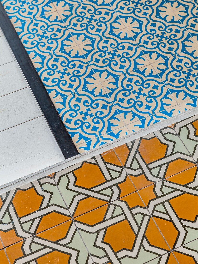 Various floor coverings: white wooden floor, ornate blue and white tiles and ochre tiles with geometric pattern