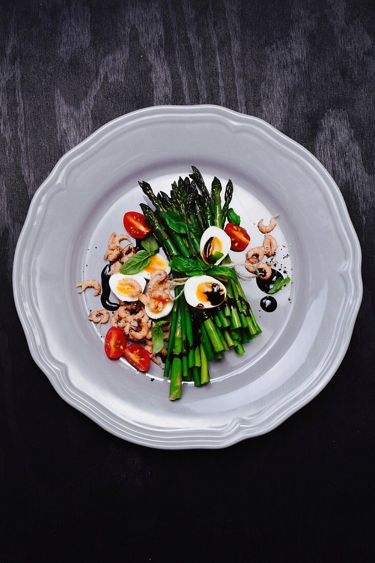 Green asparagus with quail's eggs, shrimps, tomatoes and balsamic cream