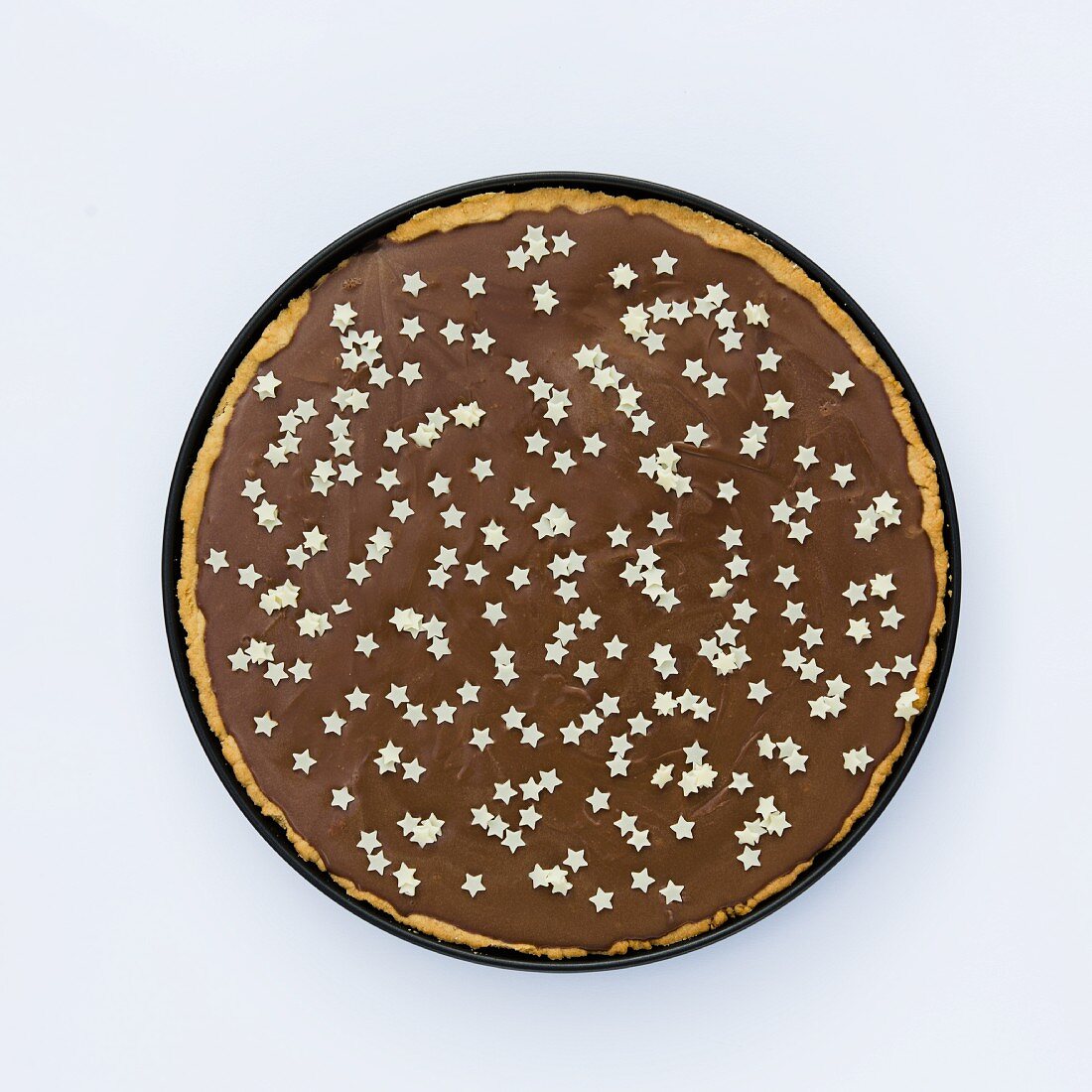 Tarte au chocolat decorated with small white stars (seen from above)