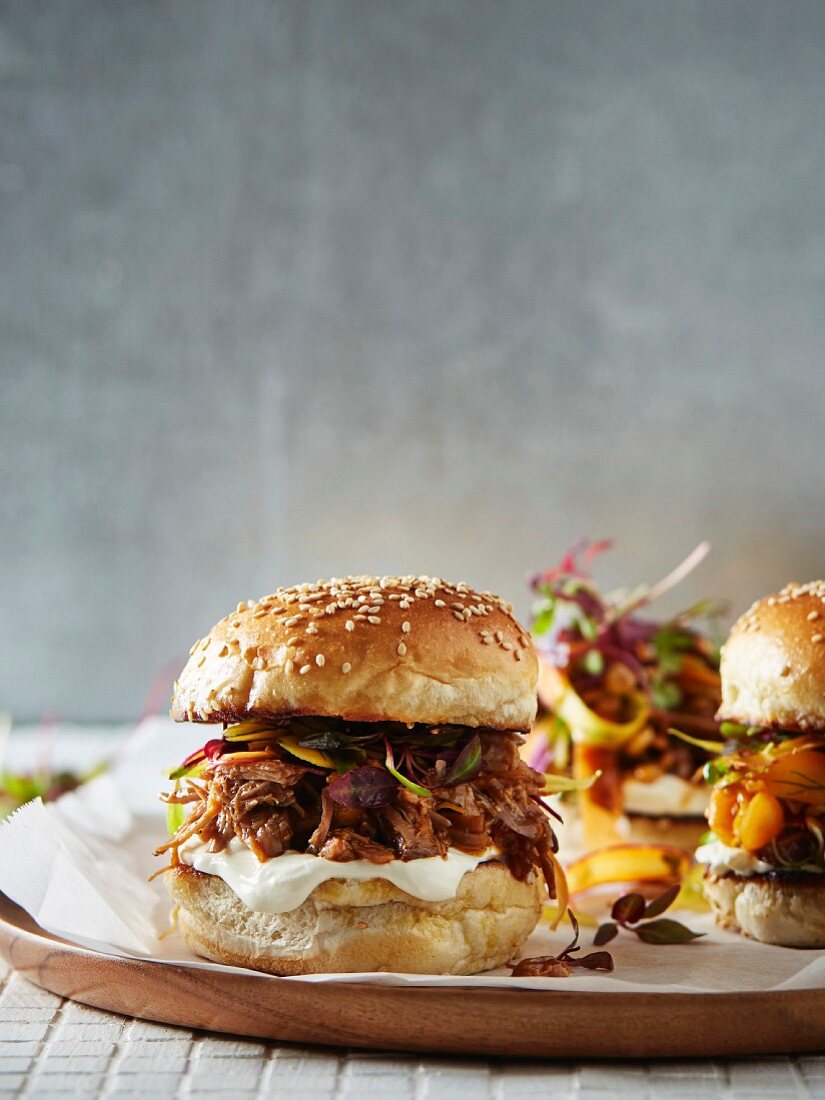 Sesame burger buns with pulled pork and physalis
