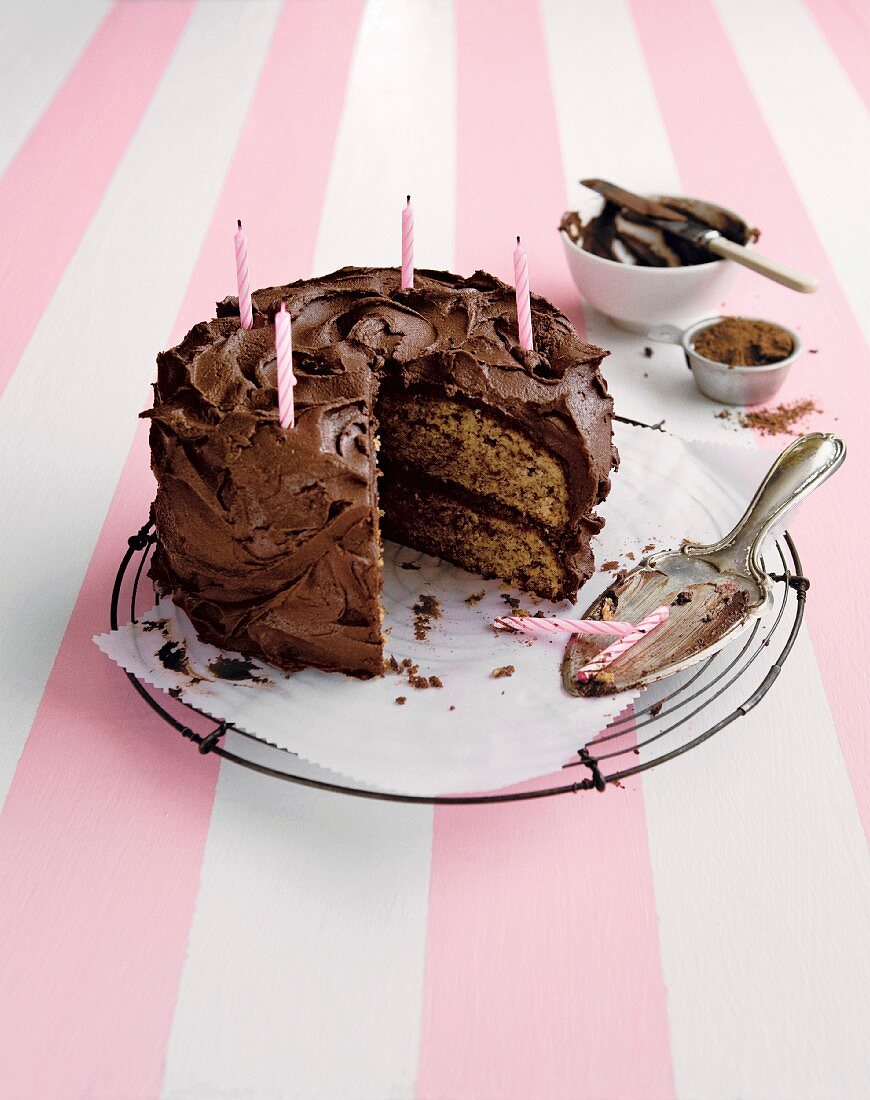 A chocolate buttercream cake with a slice cut out