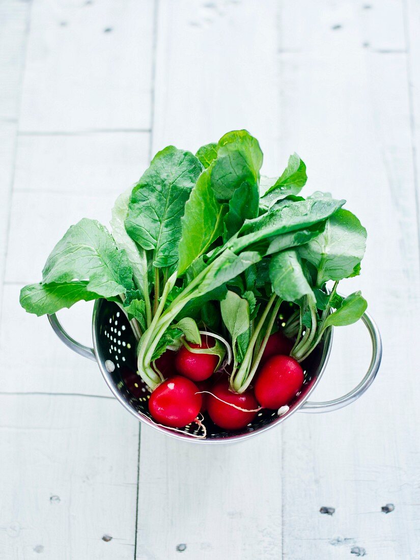 Radishes with leaves in a colander