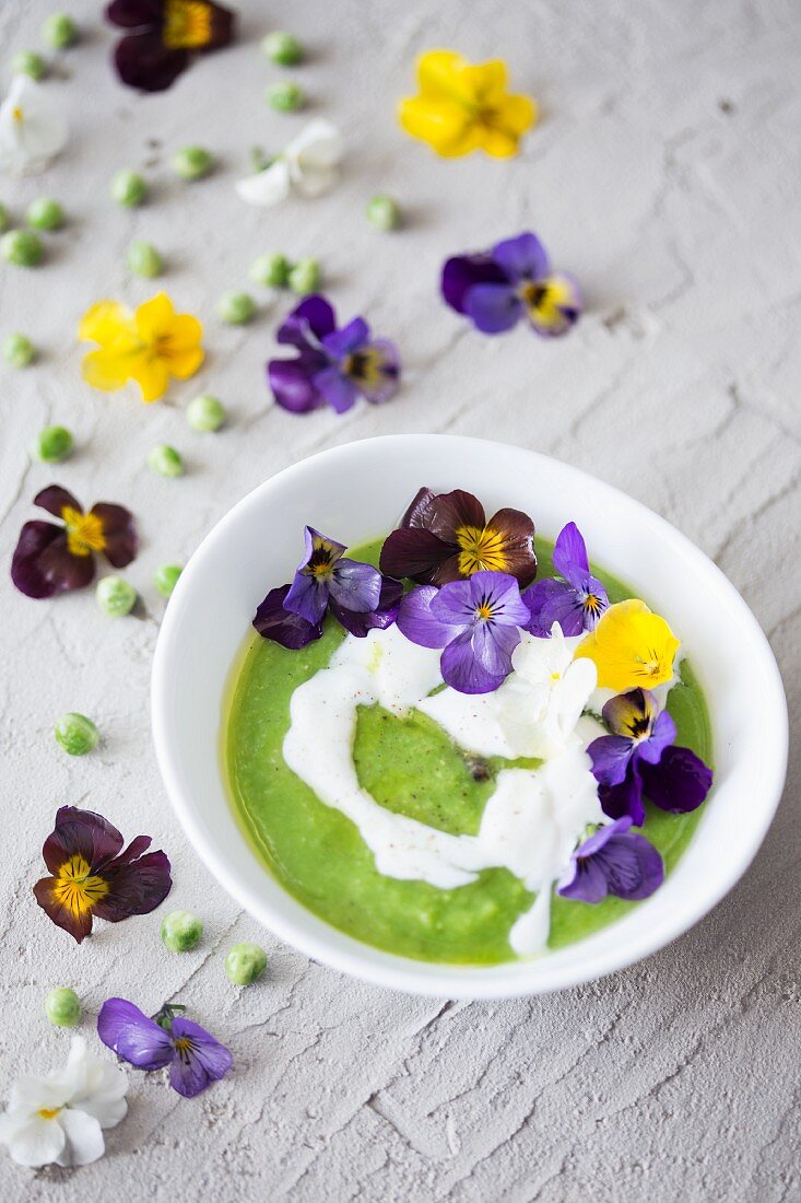 Grüne Erbsencremesuppe mit Sauerrahm und Essblüten