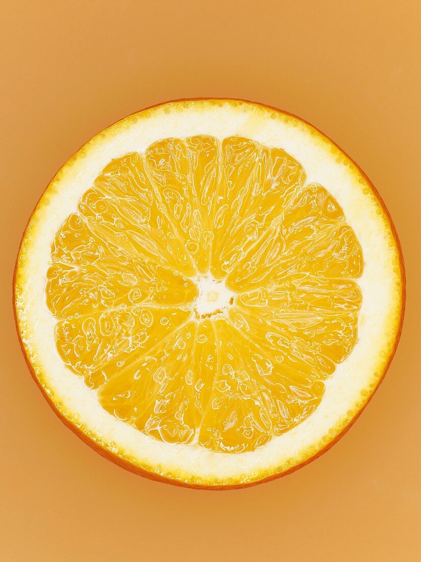 Aufgeschnittene Orange vor orangem Hintergrund, Close-Up