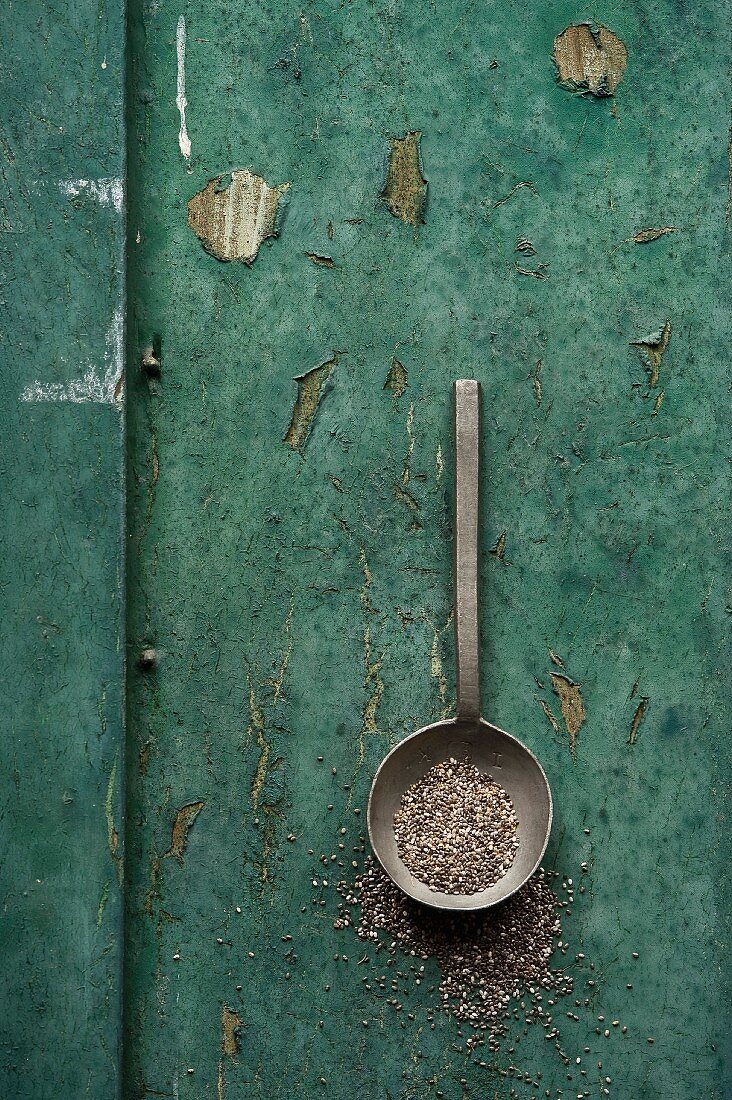 Chia seeds in a spoon on a rustic surface