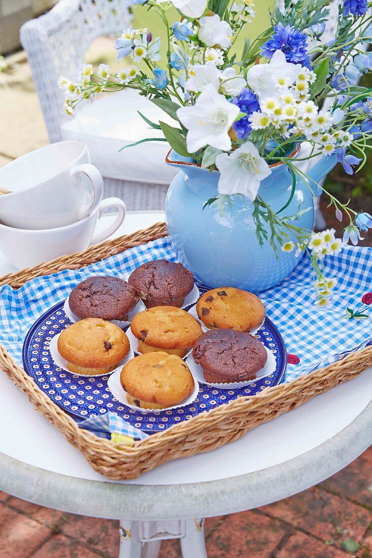Muffins und sommerlicher Blumenstrauss auf Tablett mit selbst genähtem Stoffeinsatz