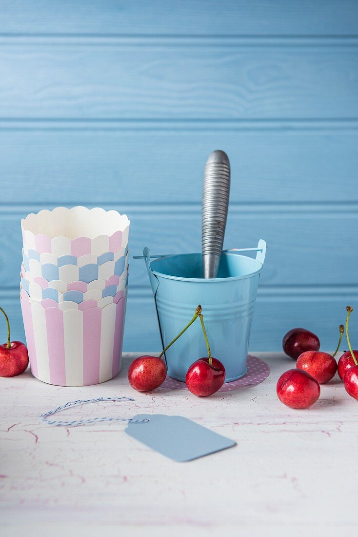 Cherries with paper cups and an ice cream scoop
