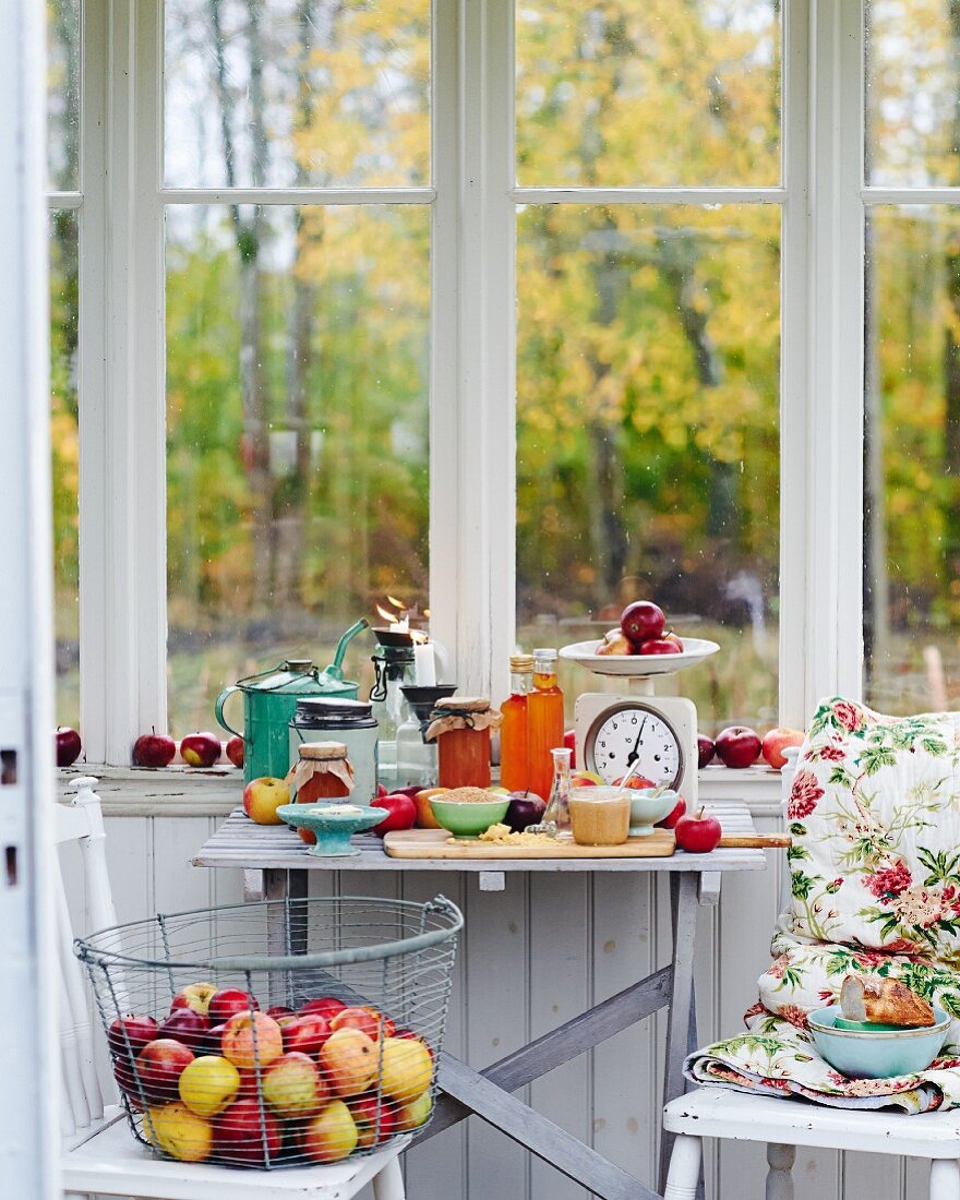 An arrangement of fresh apples and apple products in front of a kitchen window