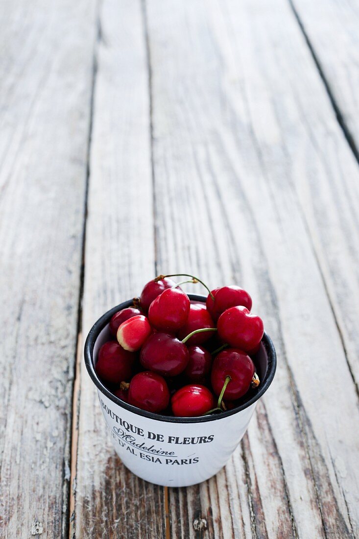 Fresh cherries in an enamel cup