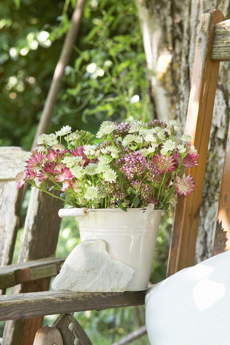 Bouquet of astrantia and marjoram in enamel bucket