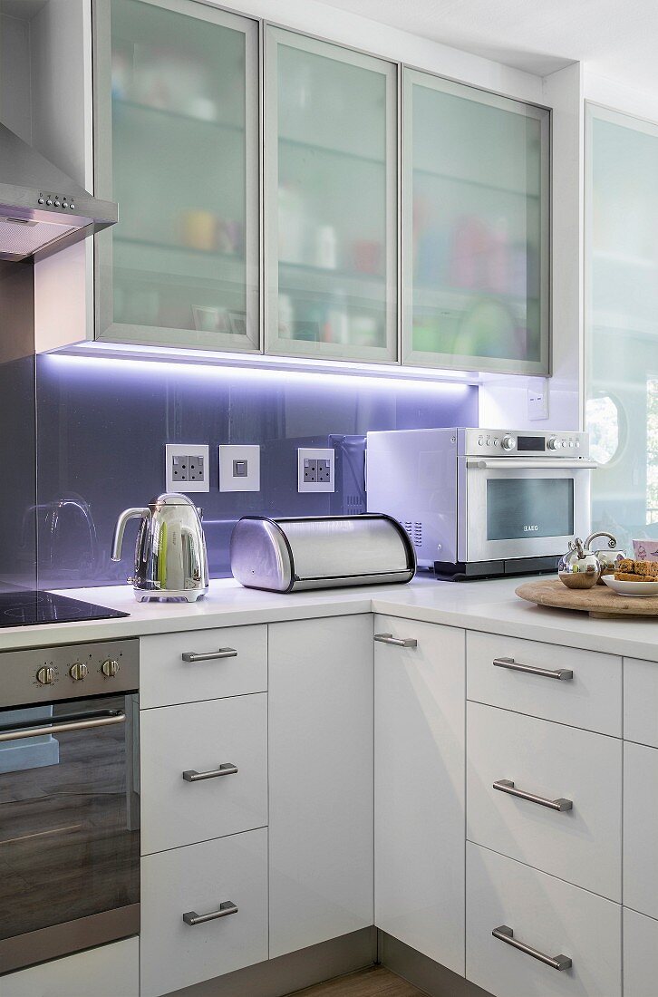 Translucent cupboards and indirect lighting in modern kitchen