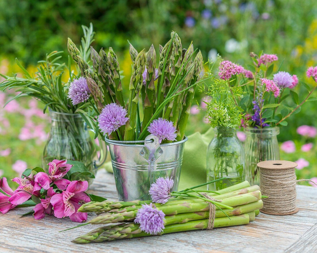 Green asparagus and fresh herbs on a garden table