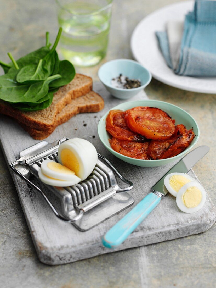 Zutaten für Sandwich mit gebratenen Tomaten, Spinat und hartgekochtem Ei