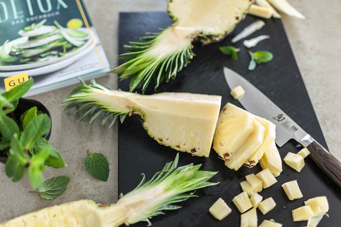 Freshly cut pineapple on a black chopping board