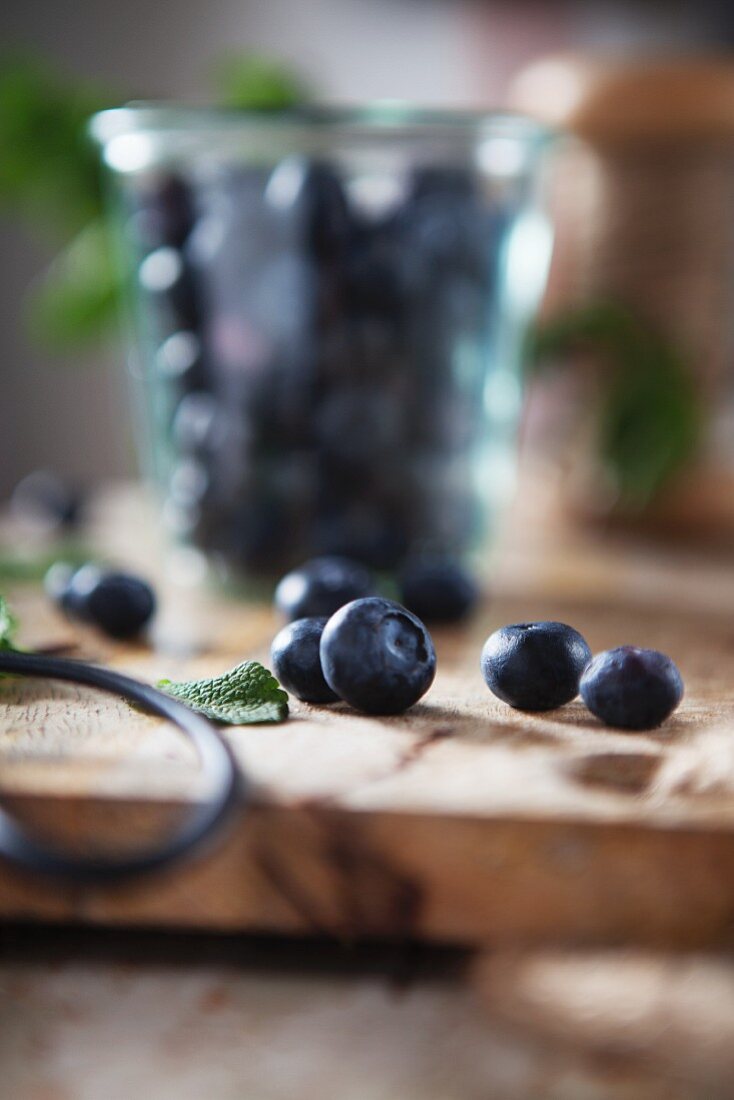 Fresh blueberries with mint and herb scissors on a wooden work surface