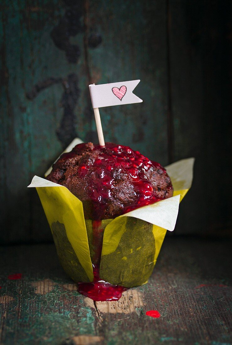 Chocolate muffin with raspberry sauce and paper flag