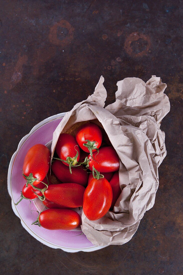 San Marzano tomatoes with a paper bag in a porcelain bowl