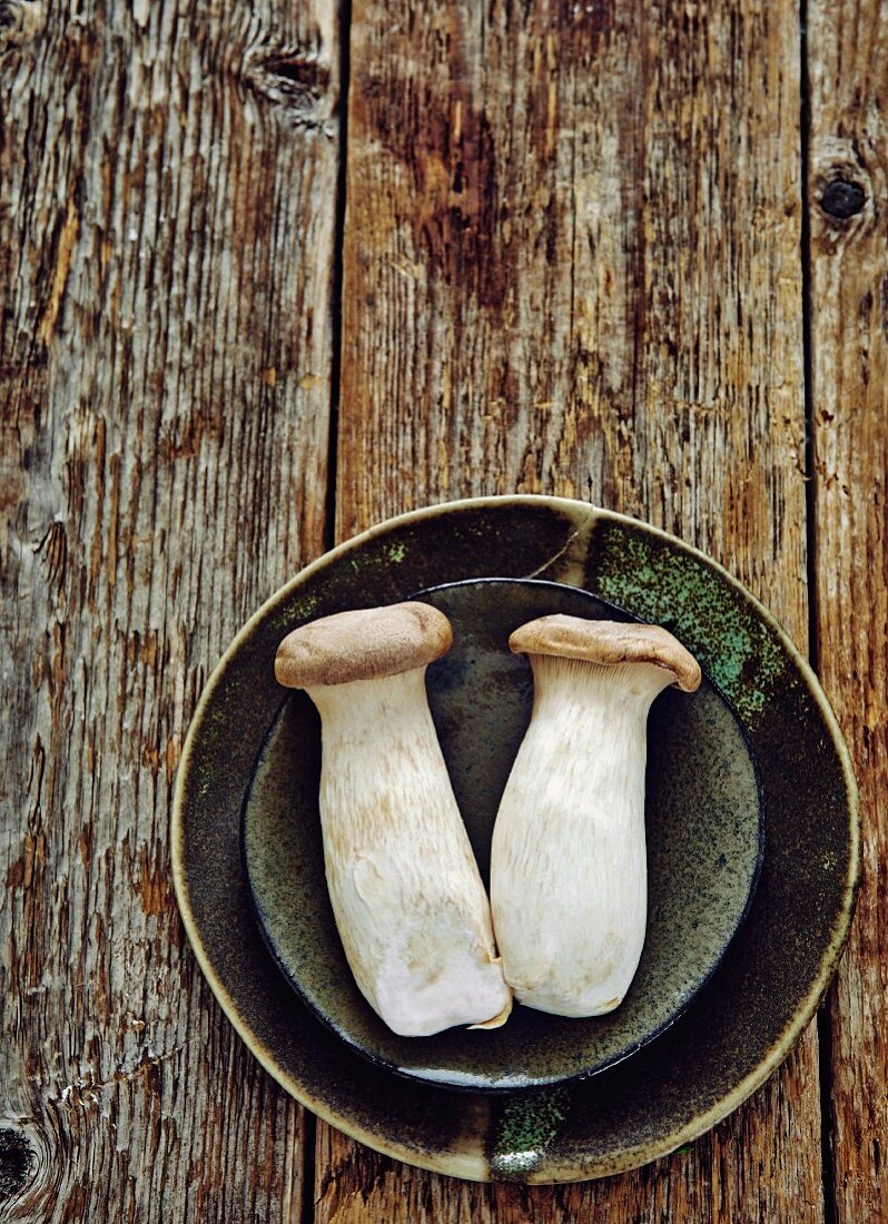 Two king trumpet mushrooms on ceramic plates