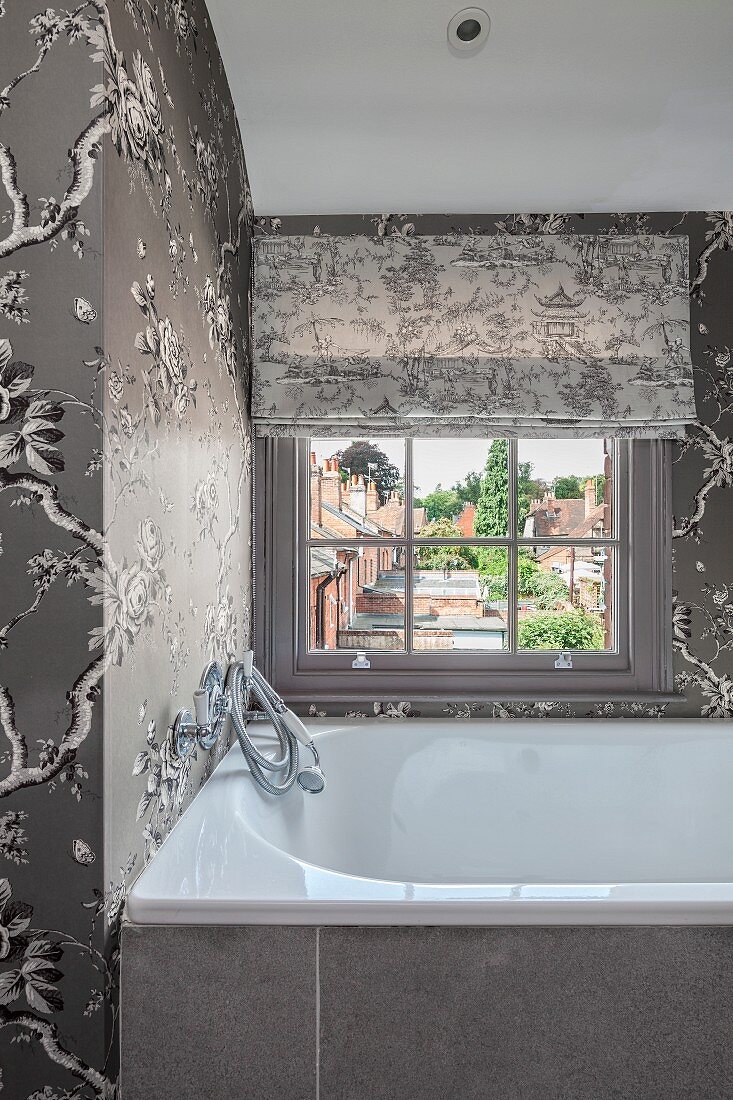 Elegant bathroom in shades of grey with floral wallpaper and lattice window
