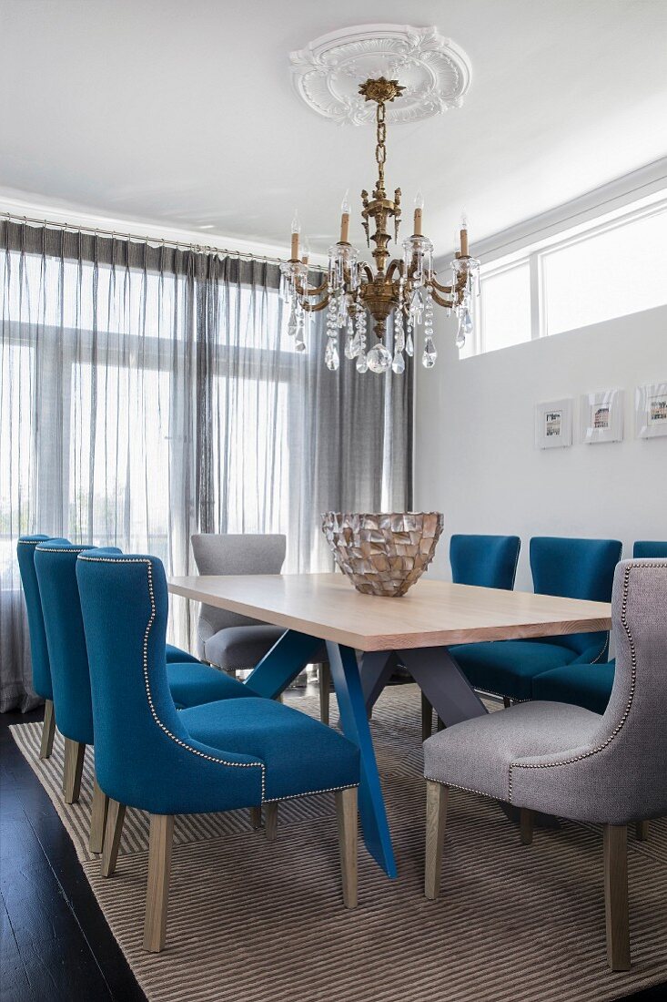 Upholstered chairs and chandelier in classic dining room