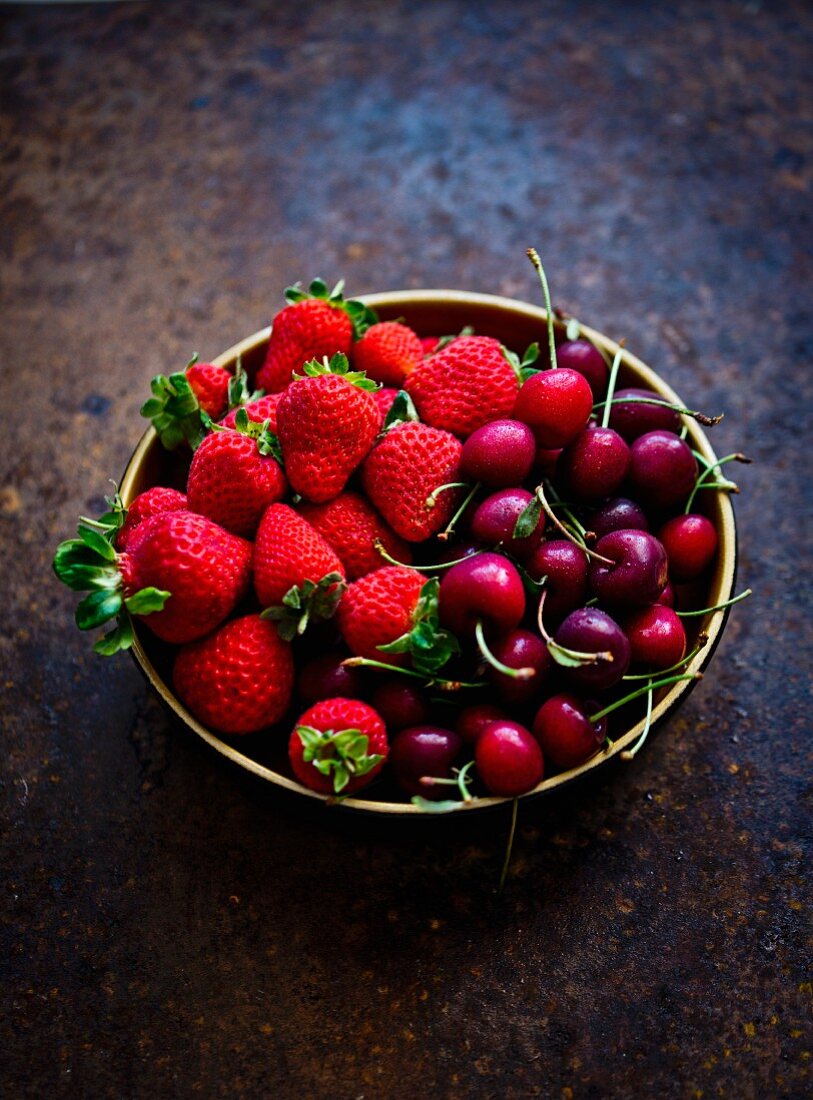 A bowl of fresh cherries and strawberries