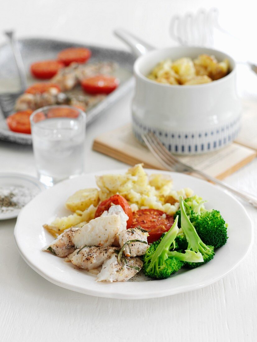 Baked monkfish with rosemary, potatoes, broccoli and tomatoes