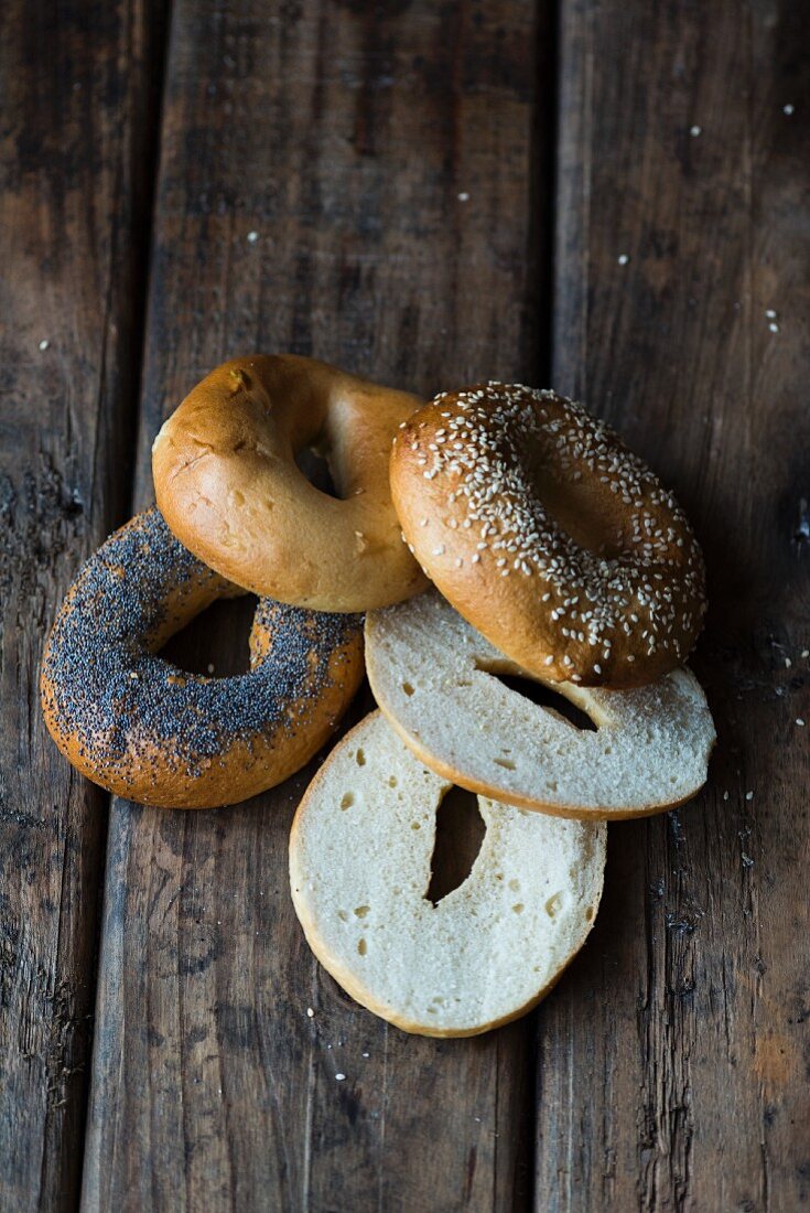 Various bagels on a dark wooden surface