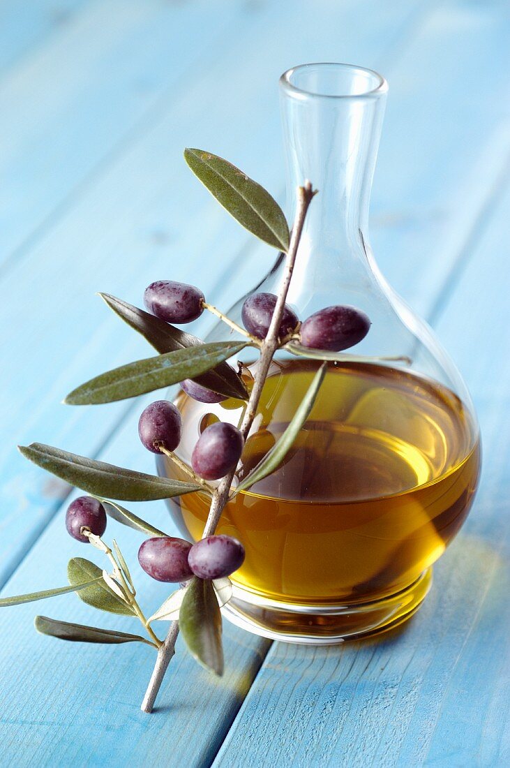 Olivenölkaraffe und Olivenzweig