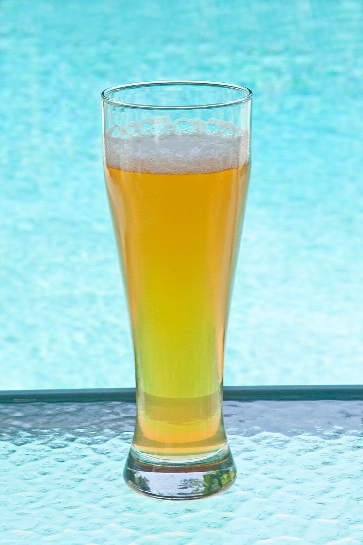 Ein Glas kaltes Bier bei einem Swimmingpool