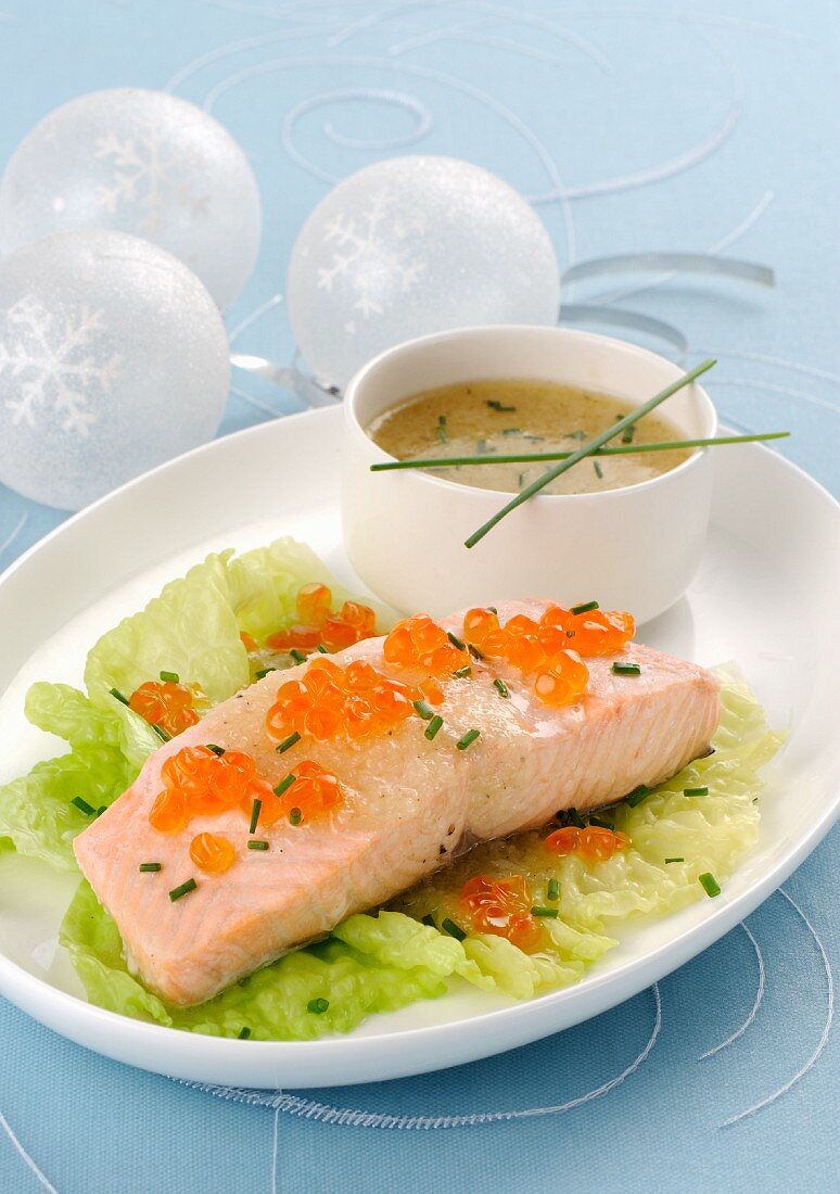 Gedünstetes Lachsfilet auf Salatblatt mit Lachskaviar und Schnittlauch