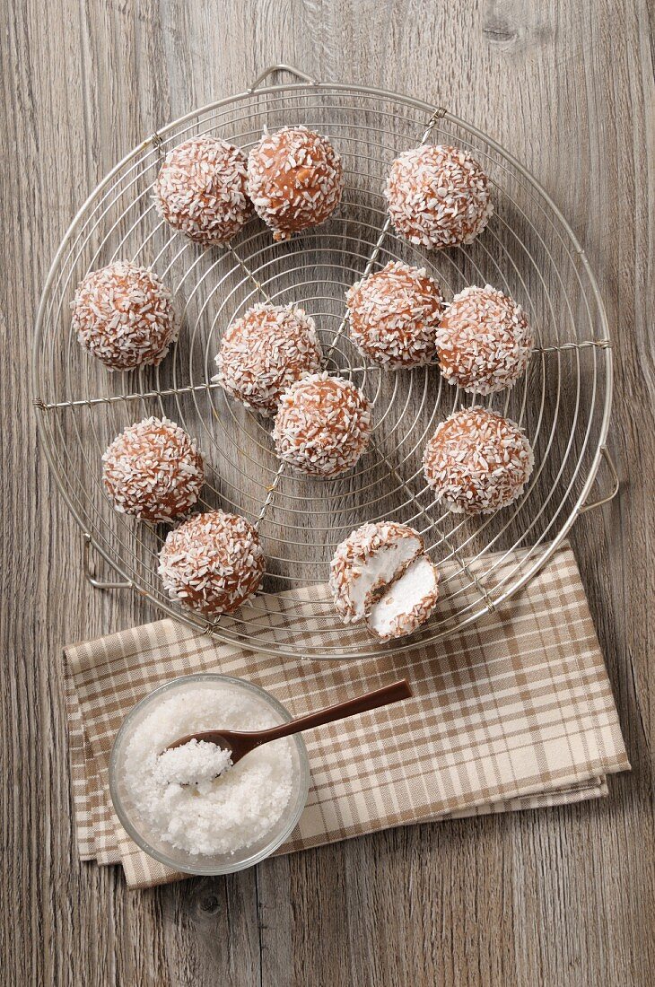 Coconut bites with grated coconut on a wire rack