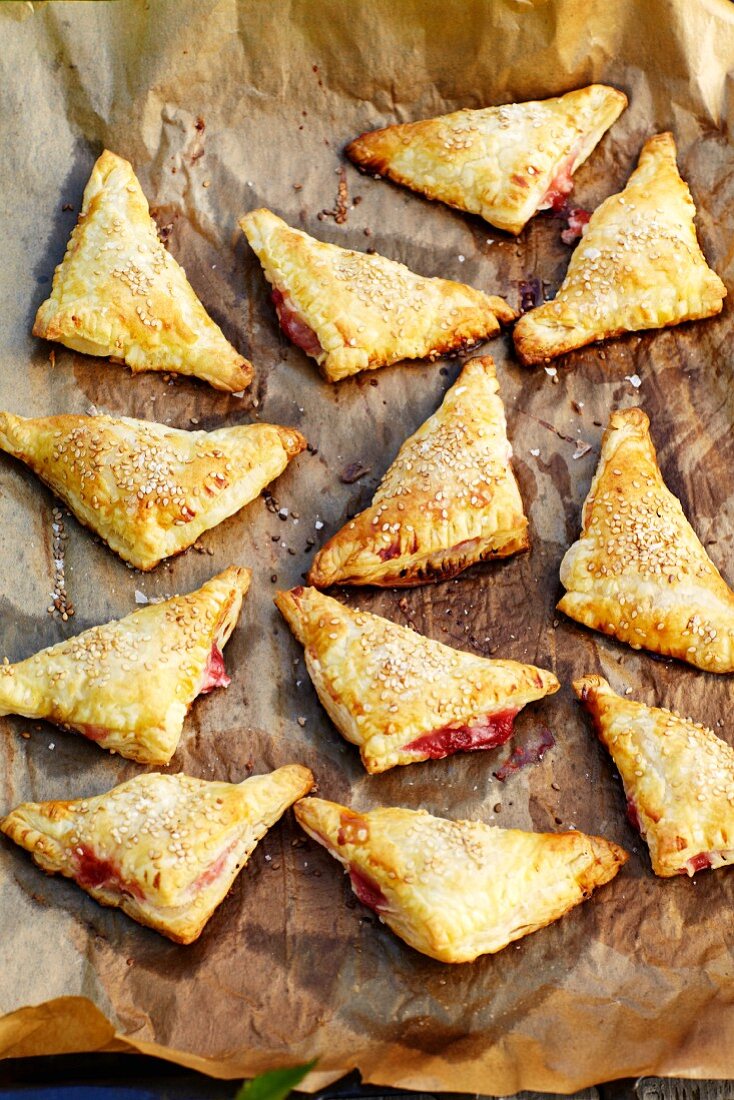 Puff pastry rhubarb turnovers on a piece of baking paper