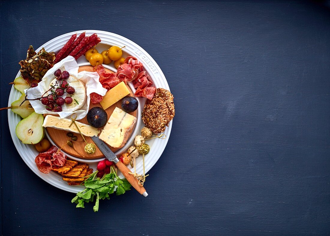 Cheese platter with fruit, vegetables and meats