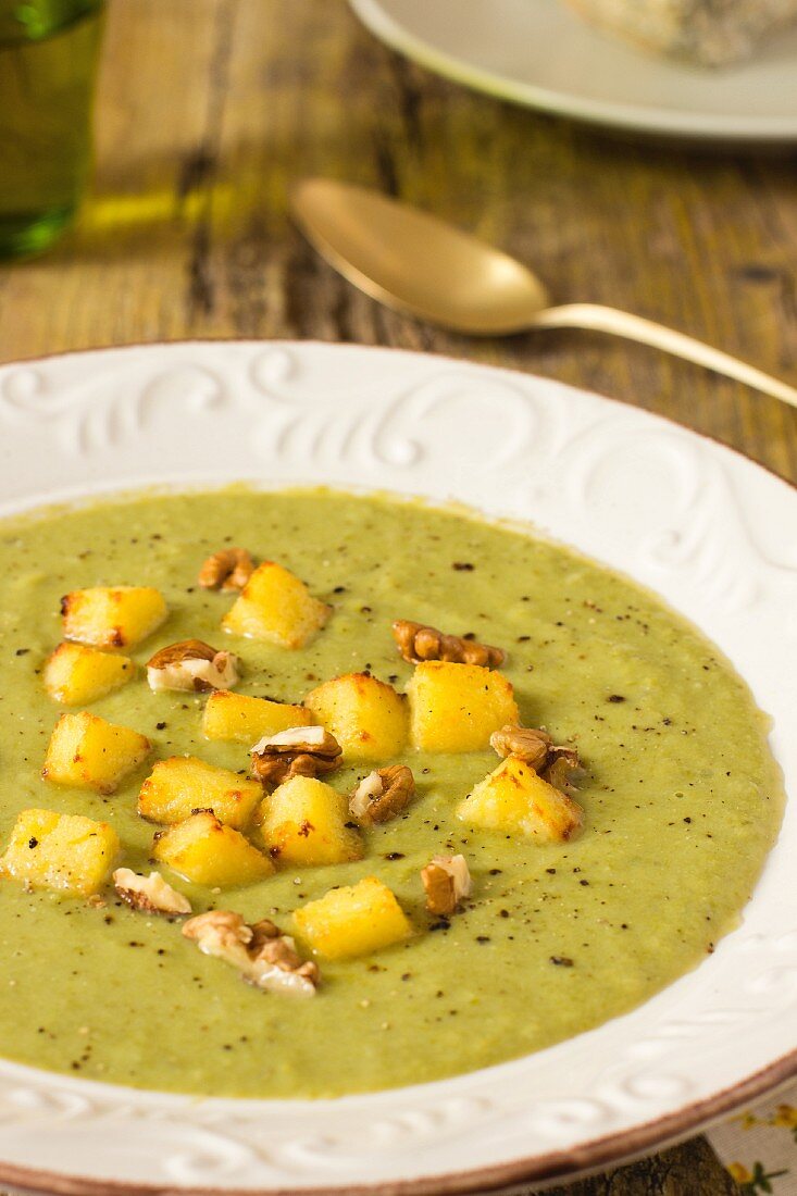 Green soup with diced polenta and walnuts