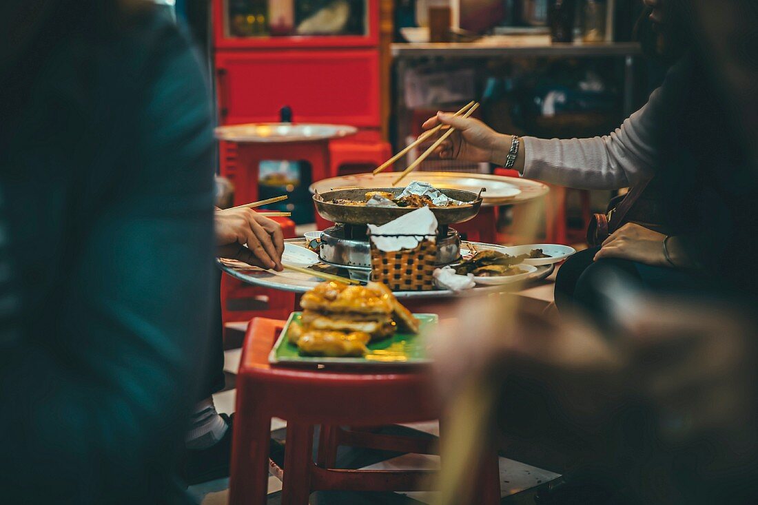 People eating with chopsticks in a restaurant