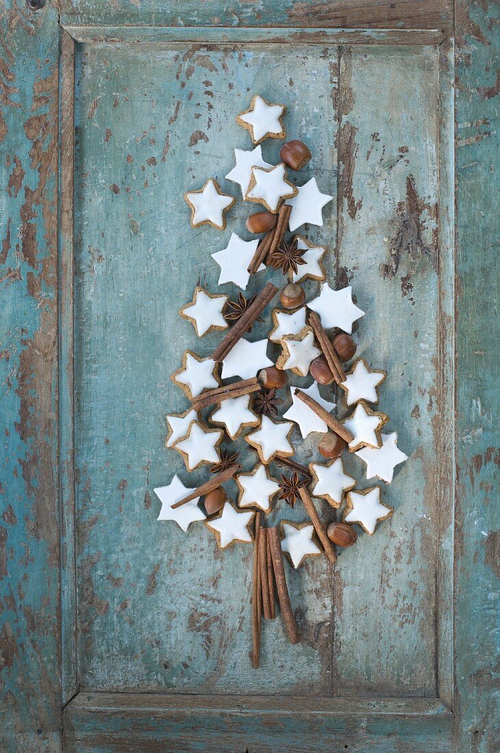 Cinnamon stars, cinnamon sticks, star anise and hazelnuts in the shape of a Christmas tree