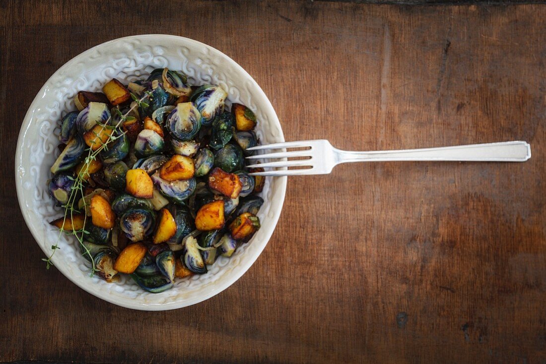 Brussels sprouts with fried potatoes in a bowl (vegetarian)