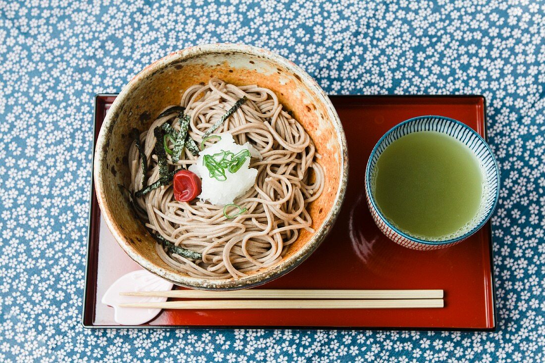 Soba-Nudeln und grüner Tee auf asiatischer Servierplatte (Japan)