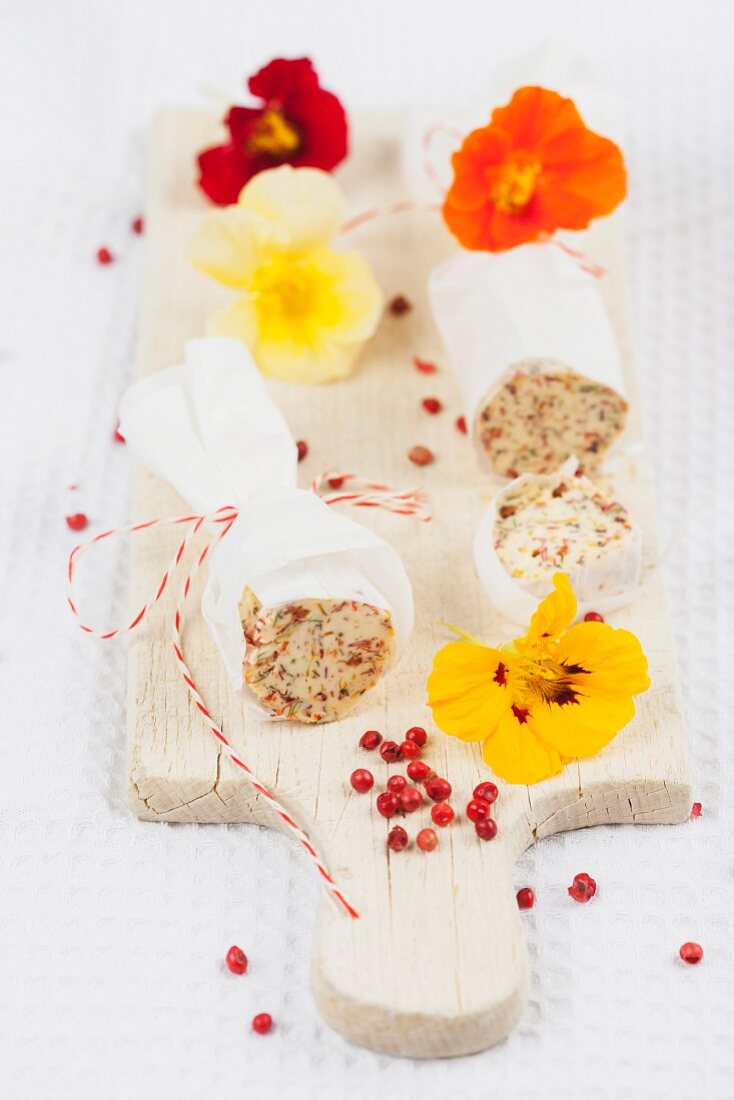 Selbstgemachte Butterrolle mit Kapuzinerkresse und roten Pfefferbeeren