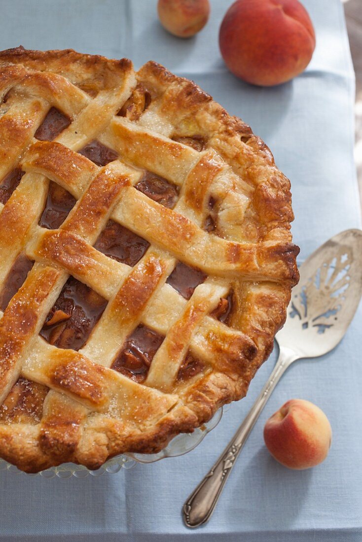 A whole peach pie with a lattice lid