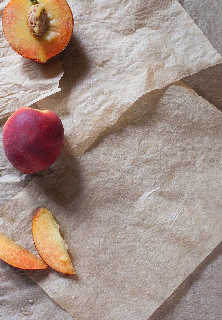 Fresh peaches, whole, halved and sliced (seen from above)