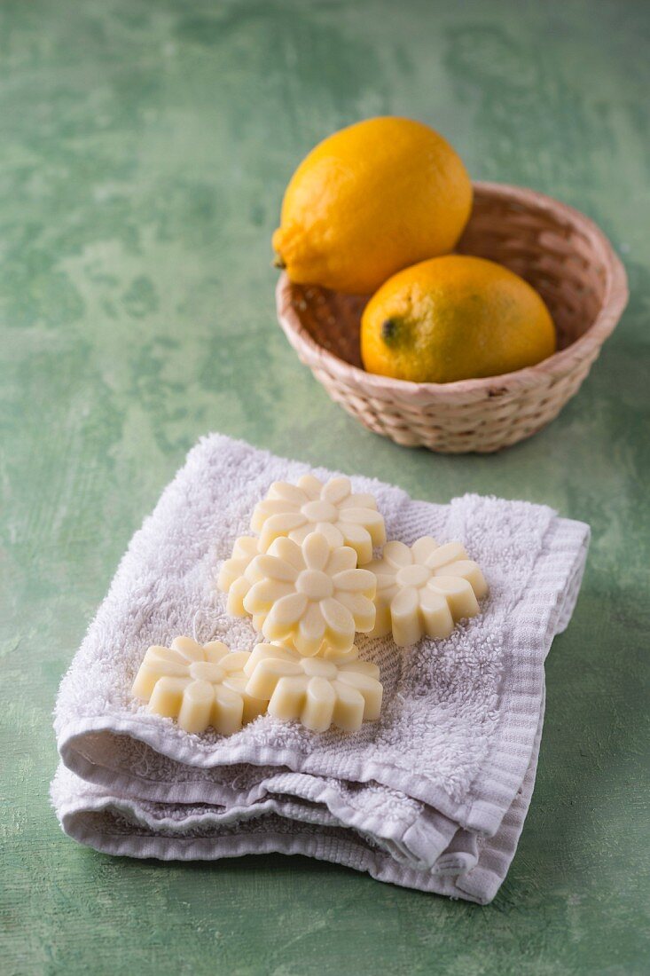 Badepralinns mit Zitronenduft auf Waschlappen, Zitronen in der Schüssel