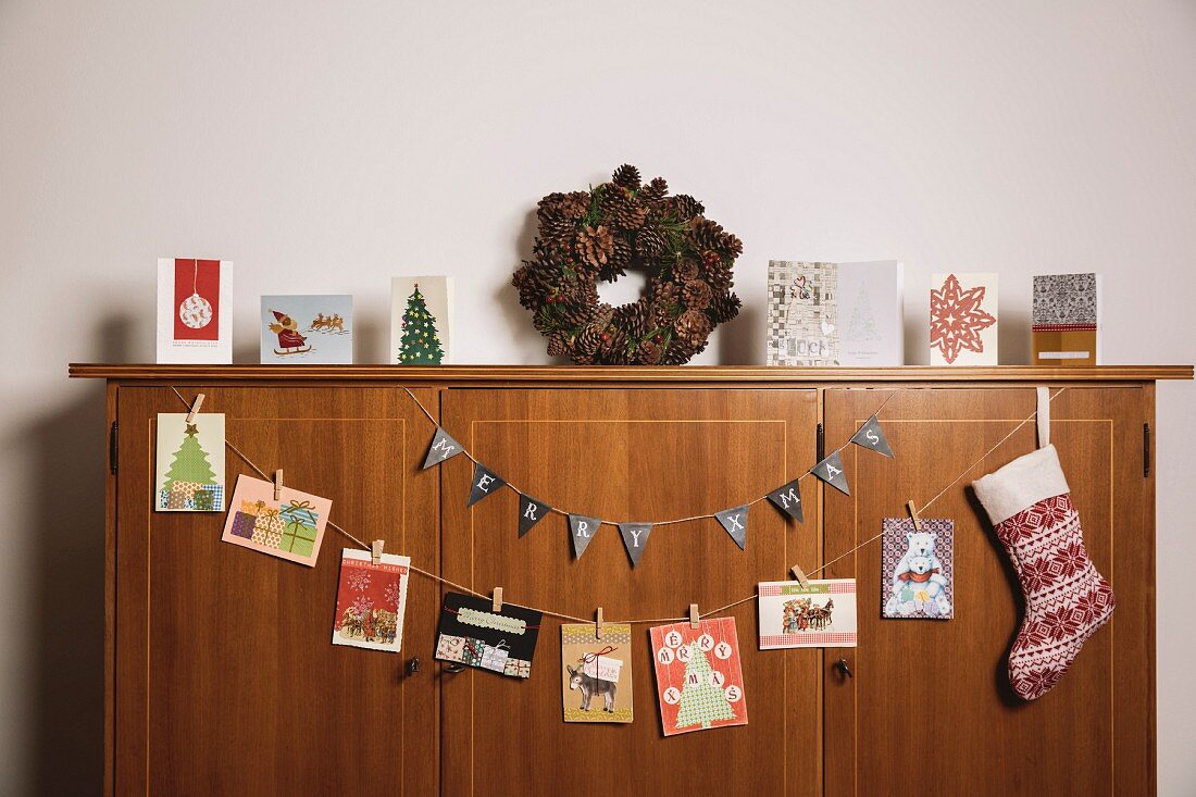Weihnachtskarten hängen an einem Sideboard aus Holz