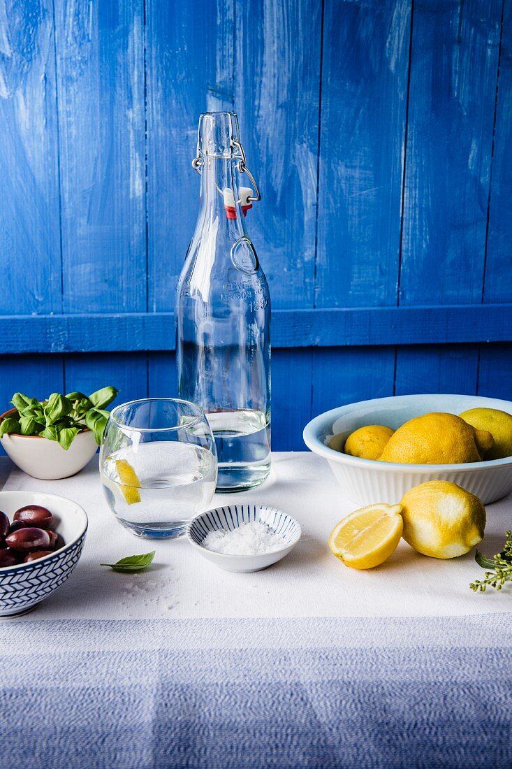Mediterraner Tisch mit Zitronen, Basilikum und Oliven