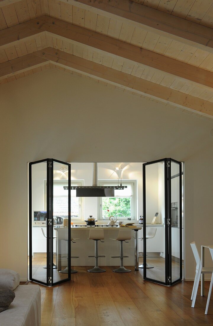 Blick durch eine moderne Falttür aus Glas in die Küche